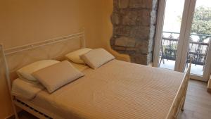a bed with two pillows on it in a bedroom at Apartments Opatija-Ičići in Ičići