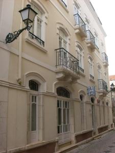 un edificio con balcones y luz de la calle en Hotel Leiriense, en Leiria