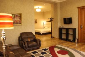 a living room with a chair and a bed at Atlas B&B Hotel in Dushanbe