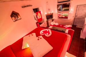 a living room with a red couch with pillows at Agriturismo La Camporena in Greve in Chianti