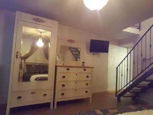 a bedroom with a dresser with a mirror and a staircase at La Tana Cerdomare in Poggio Moiano