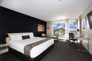 纽卡斯尔BEST WESTERN PLUS Apollo Hotel Newcastle的一间配有床、书桌和窗户的酒店房间