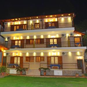 a large white building with a balcony at night at Vaya Apartments & Studios in Platamonas