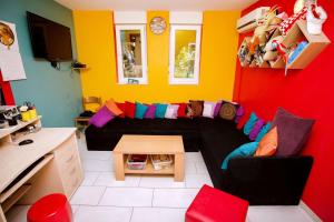 uma sala de estar com um sofá preto e paredes coloridas em Outlanders Tribe Hostel em Split