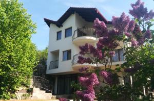 a building with purple flowers in front of it at Calea Poienii Penthouse in Braşov