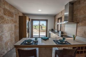 a kitchen with a counter with a table and chairs at Agroturisme Son Llado in Campos
