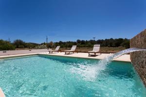 a swimming pool with a water fountain at Hort den Pilot in Sant Rafael de Sa Creu