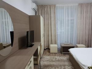 een hotelkamer met een bed en een flatscreen-tv bij Lorena Apart Old Town in Boekarest