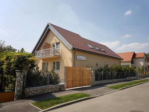 una casa con una puerta de madera y una valla en Babi Guesthouse - Babi Vendégház, en Balatonfüred