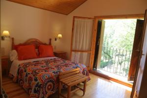 1 dormitorio con cama con banco y ventana en Casa Santafe, en San Juste