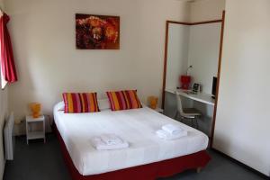 Un dormitorio con una cama blanca con toallas. en Résidence du Rougier en Camarès