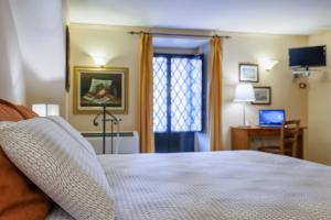 een slaapkamer met een bed en een bureau met een laptop bij Case Vacanze Catania in Catania