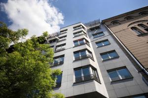 un alto edificio bianco con finestre e un albero di Apartments Belgrade a Belgrado