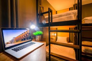 喀比的住宿－斯瑞蘇克桑特廣場旅舍，一张桌子上的笔记本电脑,放在一个配有双层床的房间