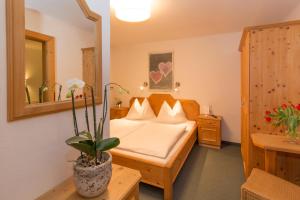 a hotel room with a bed and a mirror at Landhaus Filzmoos in Filzmoos