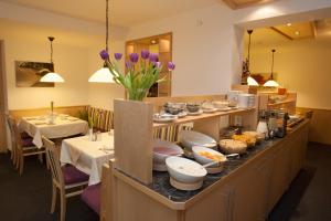 a restaurant with a buffet line with dishes and flowers at Haus Mühlbach in Fiss