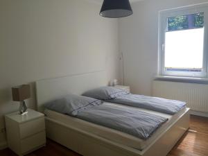 a bed in a white bedroom with a window at Haus Sonnenschein in Boltenhagen