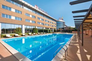 a large swimming pool in front of a building at Ramada Plaza by Wyndham Gevgelija in Gevgelija