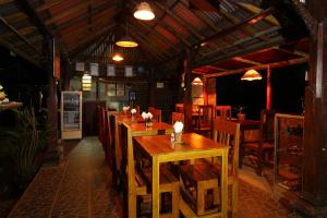 - un restaurant avec des tables et des chaises en bois dans une chambre dans l'établissement Edy Homestay, à Munduk