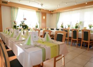 d'une salle de conférence avec des tables et des chaises et des fleurs. dans l'établissement Gasthof zur Post, à Vohenstrauß