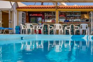 una piscina de agua con sillas y un bar en Paul Marie Hotel Apartments, en Ayia Napa
