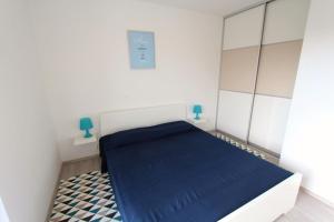 a bedroom with a bed with a blue blanket at Rabac 1 in Rabac