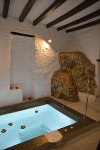 bañera de hidromasaje en una habitación con una roca en Fimaira 2, en Ermoupoli