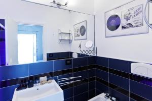 ein blau-weißes Bad mit einem Waschbecken und einem Spiegel in der Unterkunft Bed & Blues in Torre Lapillo