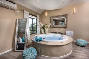 un ampio bagno con vasca e due sedie blu di Champagne suites a Kefar Weradim