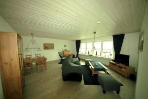 a living room with a couch and a table at Ferienhaus Kiefhuck in Nordstrand
