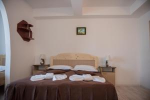 a bedroom with a bed with two towels on it at Hotel Dynes in Eforie Nord