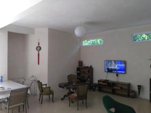 a living room with a table and chairs and a tv at Villa Vachnadze in Shekvetili