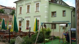a building with tables and umbrellas in front of it at Hotel Krakonoš in Trutnov