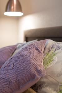 a purple pillow on a bed with a lamp at Delis Apartments - Dluga Street 11/3 in Krakow