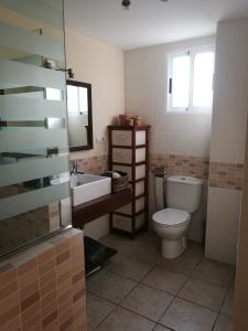 een badkamer met een toilet, een wastafel en een spiegel bij APARTAMENTO PRIMERA LINEA de la playa de Gandía in Gandía