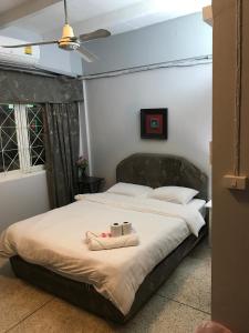 a bedroom with a bed with two towels on it at Scandalic Bar and Guest house in Pattaya