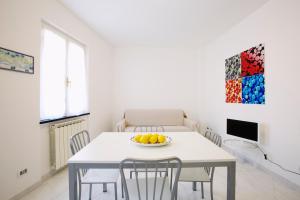 a dining room with a table with chairs and a bowl of fruit at Riviera Apartments in Levanto