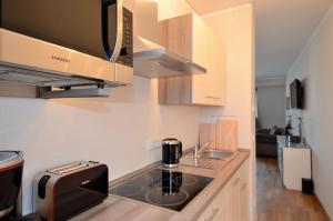 eine kleine Küche mit Spüle und Mikrowelle in der Unterkunft Dresden City Exklusiv in Dresden + 9 Fotos