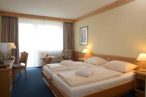 um quarto de hotel com duas camas e uma secretária em Hotel Kaiseralm em Bischofsgrün