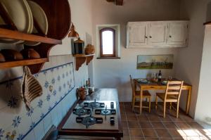 cocina con fogones y mesa. en Agriturismo Montecorboli, en Barberino di Val d'Elsa