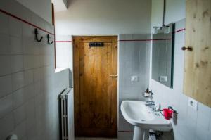 a bathroom with a sink and a wooden door at Agriturismo Montecorboli in Barberino di Val dʼElsa