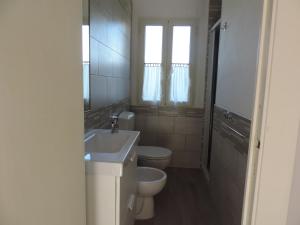 a bathroom with a sink and a toilet and a window at Appartamento Cavo in Cavo