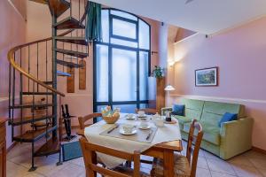 uma sala de estar com uma mesa e uma escada em espiral em Case Vacanze Catania em Catânia