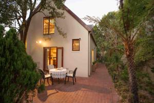 a patio with a table and chairs in front of a house at Meadows Mountain View in Hout Bay