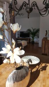 una sala de estar con un jarrón con flores blancas. en Apartment, en Flensburg