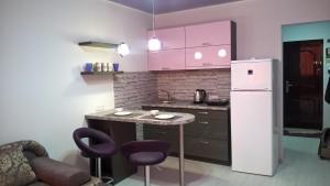 a kitchen with a table and a refrigerator at U Samogo Sinego Moria in Zatoka