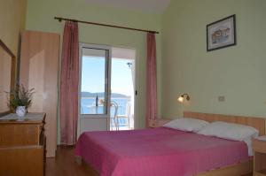 1 dormitorio con cama rosa y balcón en Apartments Majstrovic en Živogošće