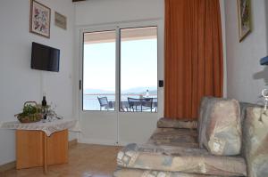 a living room with a couch and a view of the ocean at Apartments Majstrovic in Živogošće