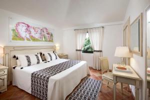 una camera con un letto e una finestra con un albero di Natale di I Giardini di Cala Ginepro Hotel Resort a Cala Liberotto