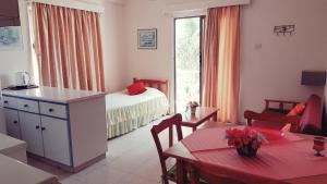 a room with a kitchen and a bedroom with a bed at Milounapa in Ayia Napa